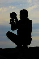 Silhouette of a photographer taking pictures photo