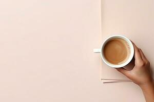 AI Generated, top view of a hand holding a cup of coffee. On a pastel pink paper background photo