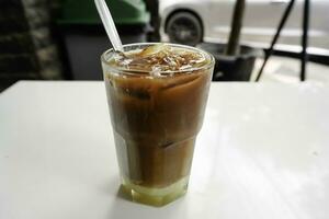 A glass of iced coffee milk kopitiam style, showing separate in a layer the bottom as milk top by coffee. photo