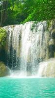 natuurlijk landschap van mooi erawan watervallen in een tropisch regenwoud milieu en Doorzichtig smaragd water. verbazingwekkend natuur voor avonturiers video