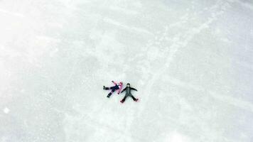 two people laying on the ice in the snow video