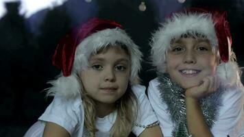 dos niños vistiendo Papa Noel sombreros posando para el cámara video
