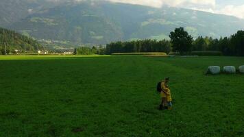 dos personas caminando mediante un campo con montañas en el antecedentes video