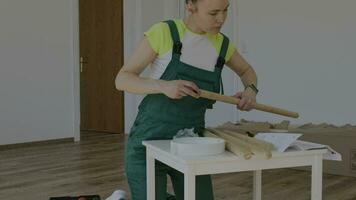 a woman in overalls is working on a table video