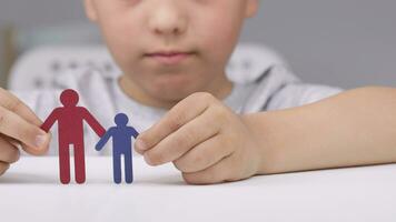 a person holding a paper man figure on a table video