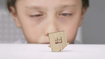 a boy looking at a wooden house with a window video