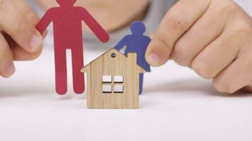 a person holding a paper cutout of a family with a house video