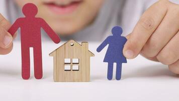 a person holding a paper cutout of a family with a house video