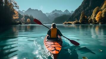 Rear view of woman riding kayak in stream with background of beautiful landscape. photo
