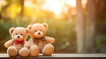 Two teddy bear toys sitting on bench at sunset. photo