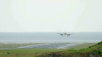 a avião aterrissagem às a recorrer. a avião aterrissagem sobre a de praia. avião aterrissagem sobre a de praia contra a Palma árvores avião aterrissagem dentro phuket video