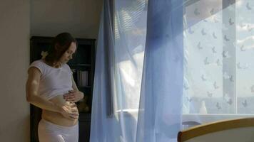 een zwanger vrouw staand in voorkant van een venster video