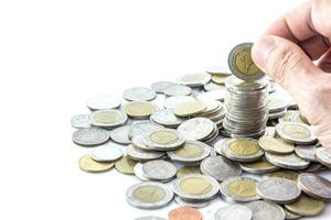 Hand put coins to stack of coins photo