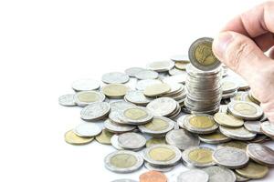 Hand put coins to stack of coins photo