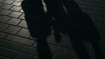 Schatten von Gehen Menschen auf das Stein Fußboden beim Straße im schleppend Bewegung video