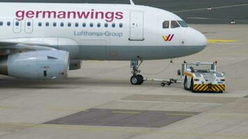 DUSSELDORF, GERMANY JULY 23, 2017 - Passenger airplane of Germanwings pulls the tractor onto the runway before departure at Dusseldorf Airport DUS. Tourism and travel concept video