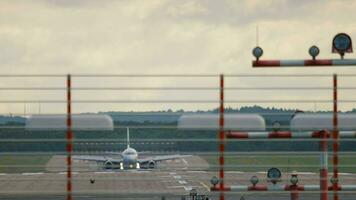 Verkehrsflugzeug angekommen, verlangsamt Nieder nach Landung. Vorderseite Aussicht von das Rollbahn von Düsseldorf Flughafen und das ankommen Ebene. Tourismus und Reise Konzept video