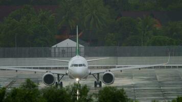 avión en el aeródromo en pesado tropical lluvia. frente vista, rodaje el avión a el pista en malo clima, Tormentoso aguacero video