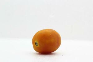 Isolated red tomato just coming out of the fridge on white background photo