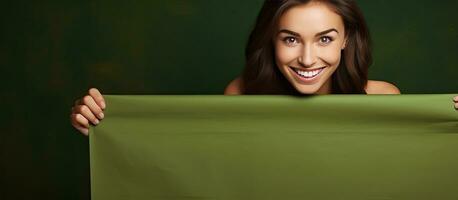 Smiling girl with green banner over brown background space for text or design photo