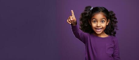 Excited Indian woman pointing at free space for advert over purple background photo