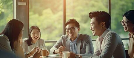 Young Asian business people having a casual discussion in a team in a startup project meeting or showcasing happy teamwork brainstorm with copy space a photo