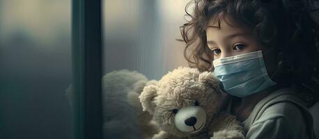 Sick child with protective mask sadly looking out the window photo