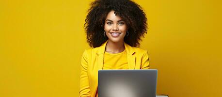 Attractive girl sitting with laptop presenting idea isolated on vibrant yellow background photo