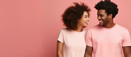 Smiling African couple looking away against pink background photo