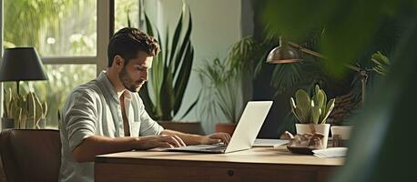 Male freelancer working remotely from home office using laptop for self employment photo