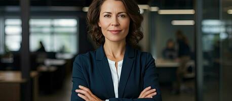 Confident happy businesswoman in office arms crossed looking at camera photo