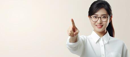 sonriente asiático mujer en blanco camisa señalando a vacío espacio foto