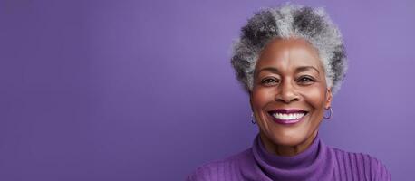 Close up portrait of happy elderly black woman smiling in front of purple backdrop room for text photo