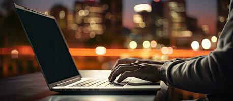 Young man using laptop at night with blurred bokeh background horizontal image size with space for text photo