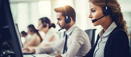 Call center employees with headsets working at their desks in office empty area photo