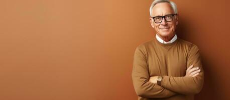 Waist up portrait of elderly man in glasses arms crossed looking at camera against beige background photo