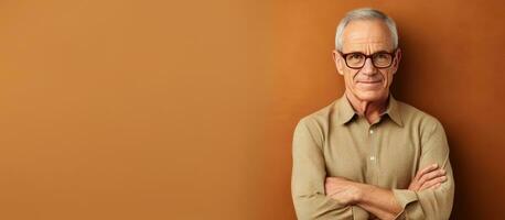 Waist up portrait of elderly man in glasses arms crossed looking at camera against beige background photo