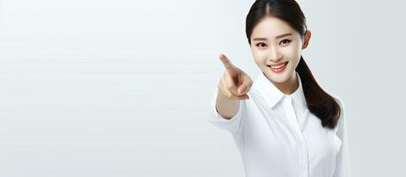 Asian woman in white shirt smiling and pointing to empty space suitable for advertising photo