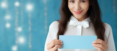 hermosa joven mujer participación blanco regalo tarjeta en azul antecedentes foto