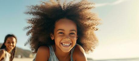 Happy black mother and daughter playing on beach with room for text Sister gives piggyback ride to little girl by the shore Lovely child hugs her mom photo