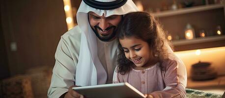 Young Arab father and his adorable daughter enjoying time together at home using a tablet for online shopping photo