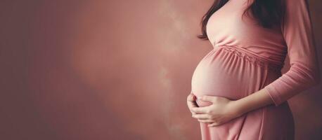 embarazada mujer con redondo barriga vistiendo rosado suéter foto