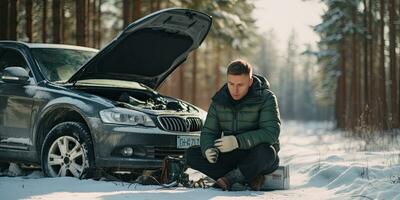 Caucasian man in snowy forest with broken down car calling mechanic Empty road photo