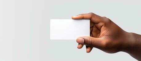 Hand of biracial man holding a black business card with empty area on white background representing the idea of business stationery and writing space photo