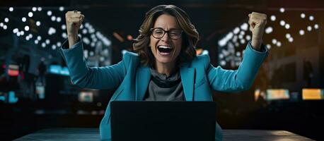 An enthusiastic middle aged woman working on her laptop at night happily pointing to the side with open palms to display a copy space for advertising purp photo