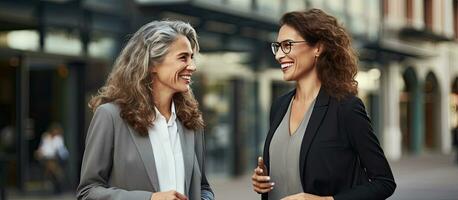 Successful middle aged women discussing business outside office photo