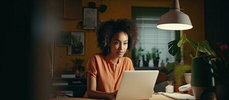 birracial mujer trabajando remotamente desde hogar utilizando ordenador portátil para negocio foto