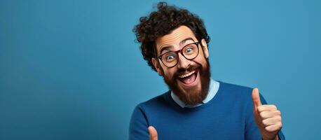 A happy bearded young man with laptop smiling and pointing to the side and upwards displaying an object in empty area photo