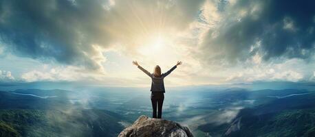 Successful businesswoman celebrating on a cliff with clouds and space for text photo