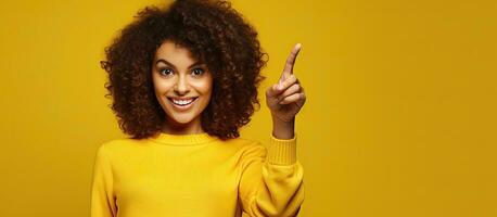 A young woman advertising an empty space for commercial text on a yellow studio background photo